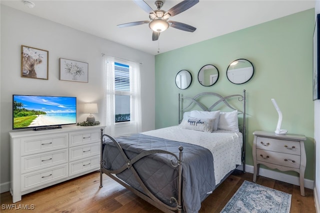 bedroom featuring a ceiling fan, baseboards, and wood finished floors