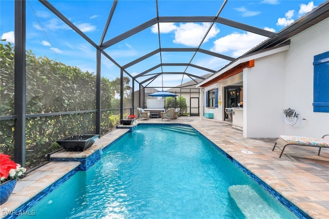 view of swimming pool featuring glass enclosure, pool water feature, and a patio area