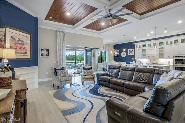 living room with coffered ceiling, light hardwood / wood-style floors, wood ceiling, ceiling fan with notable chandelier, and ornamental molding