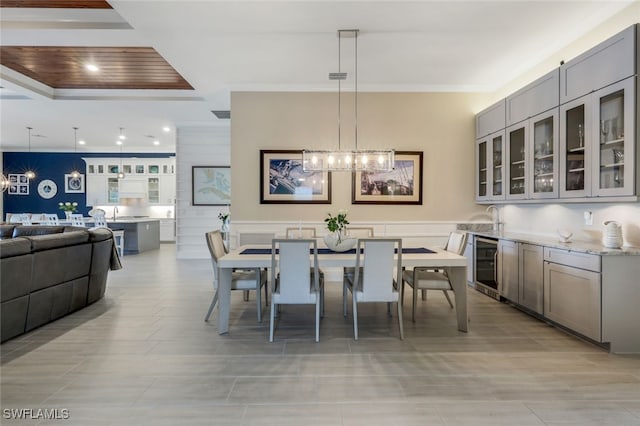 dining space featuring beverage cooler and a notable chandelier