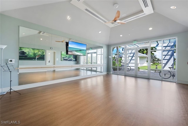 exercise room with ceiling fan, wood-type flooring, and lofted ceiling