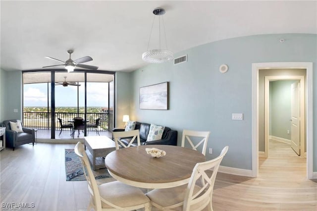 dining room with ceiling fan, floor to ceiling windows, and light hardwood / wood-style flooring