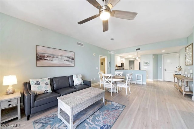 living room featuring ceiling fan and light wood-type flooring