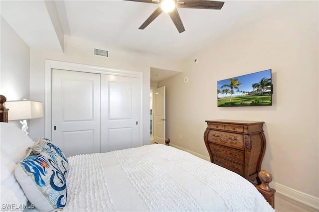 bedroom with hardwood / wood-style floors, a closet, and ceiling fan