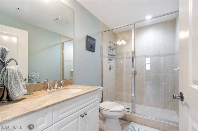 bathroom featuring vanity, toilet, and an enclosed shower