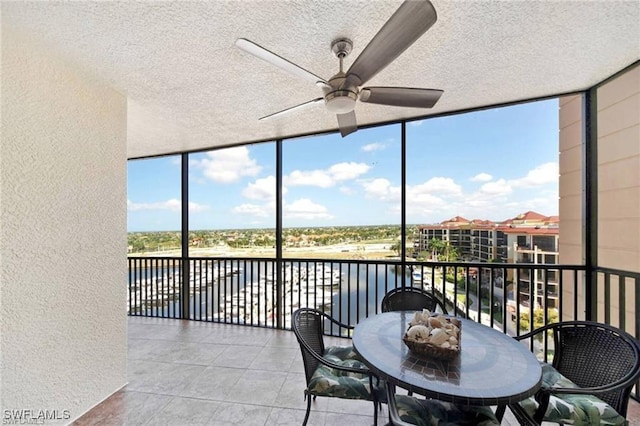 sunroom featuring a water view and ceiling fan