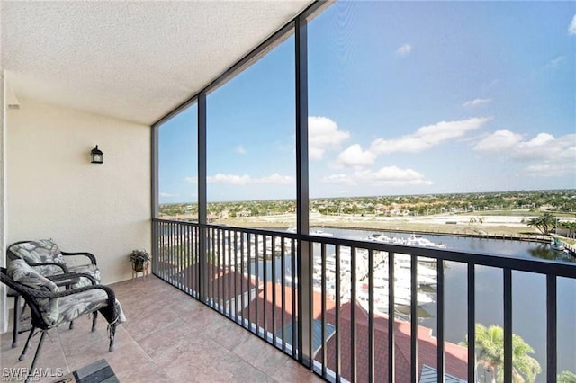 sunroom featuring a water view