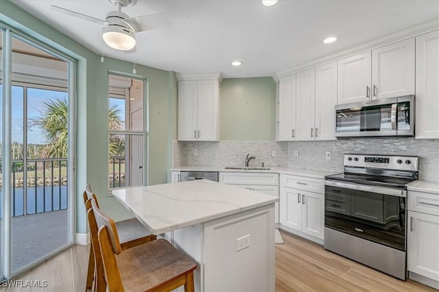 kitchen with white cabinetry, a kitchen island, and stainless steel appliances