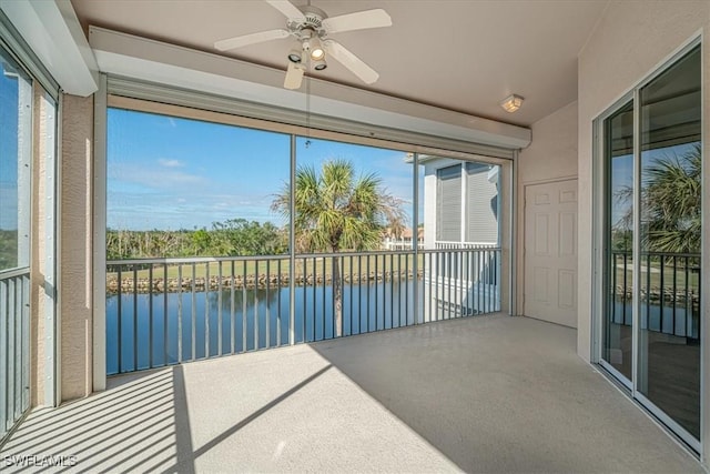 sunroom / solarium featuring ceiling fan, plenty of natural light, and a water view