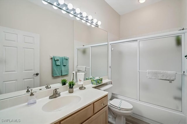 full bathroom with vanity, enclosed tub / shower combo, and toilet