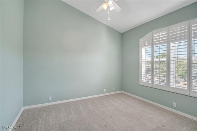 carpeted empty room with ceiling fan and vaulted ceiling