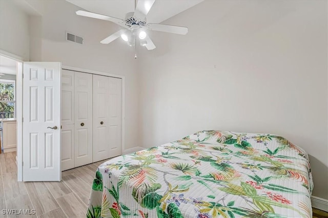 bedroom with ceiling fan, light hardwood / wood-style floors, and a closet