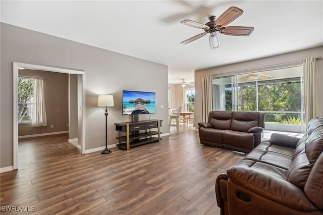 living room with ceiling fan and dark hardwood / wood-style floors