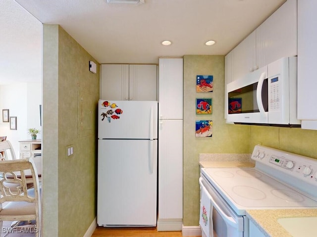 kitchen featuring white cabinetry and white appliances