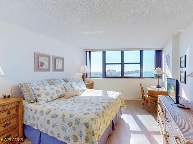 bedroom featuring a textured ceiling and light wood-type flooring