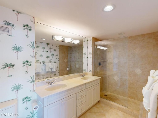 bathroom featuring tile patterned flooring, vanity, and tiled shower