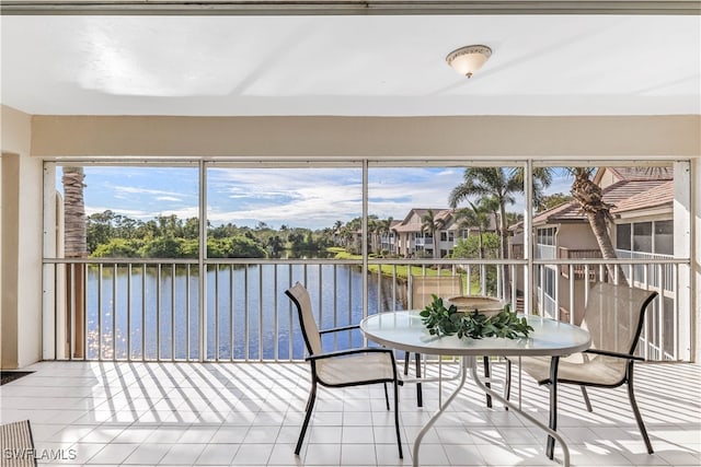 sunroom featuring a water view