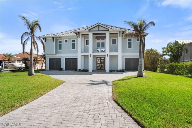 view of front facade featuring a garage, a front yard, and french doors