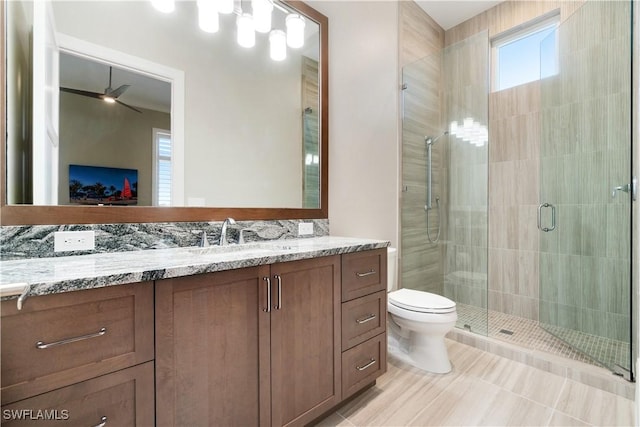 bathroom featuring vanity, tile patterned floors, ceiling fan, toilet, and an enclosed shower