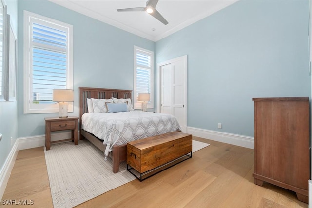 bedroom with ceiling fan, light hardwood / wood-style flooring, and multiple windows