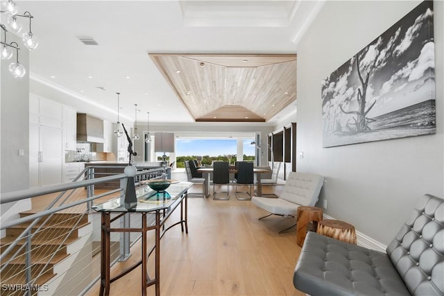 interior space with wood ceiling, light hardwood / wood-style flooring, and a tray ceiling