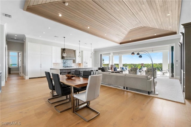 dining room featuring vaulted ceiling, light hardwood / wood-style flooring, wooden ceiling, and crown molding