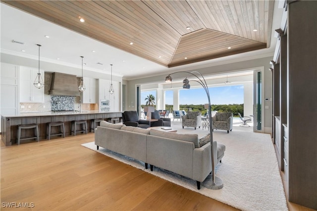 living room featuring light hardwood / wood-style floors, wooden ceiling, ornamental molding, and a tray ceiling