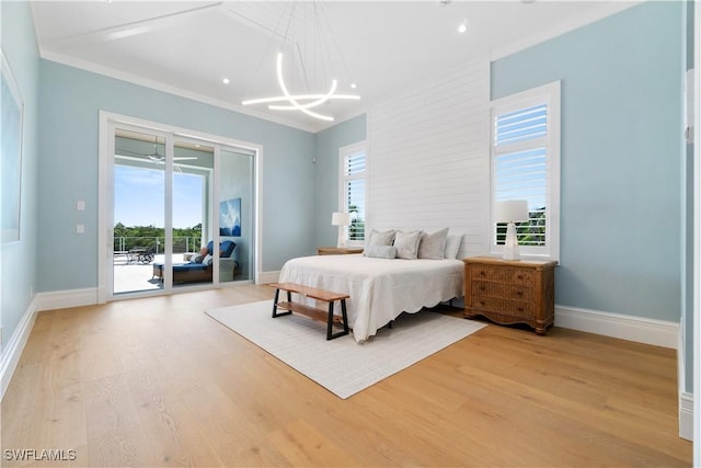 bedroom with access to exterior, light wood-type flooring, and a chandelier