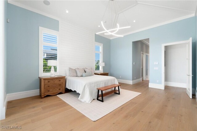 bedroom with an inviting chandelier, light hardwood / wood-style flooring, and crown molding