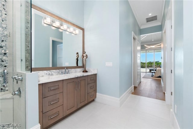 bathroom featuring hardwood / wood-style floors, vanity, a shower with shower door, and ornamental molding