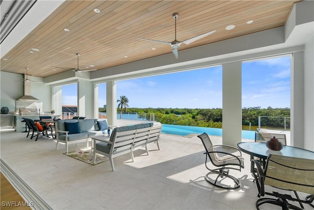 view of patio / terrace with ceiling fan, a water view, an outdoor hangout area, and a pool