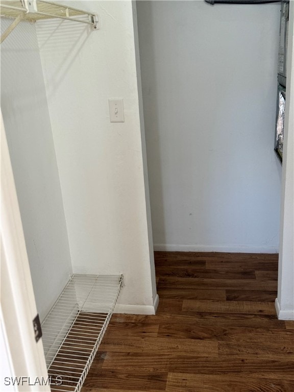 walk in closet with dark wood-type flooring