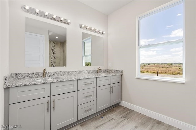 bathroom featuring hardwood / wood-style floors, vanity, and a shower