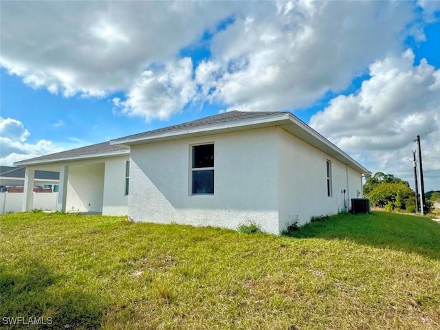 rear view of house with a yard and central AC unit