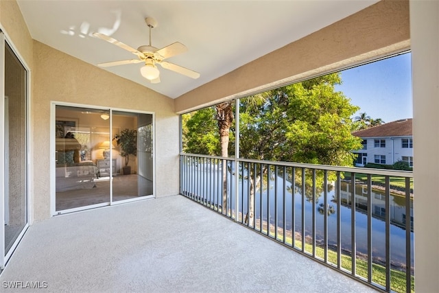 balcony featuring ceiling fan and a water view