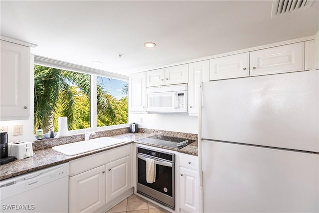 kitchen with sink, white cabinets, white appliances, and light tile patterned floors