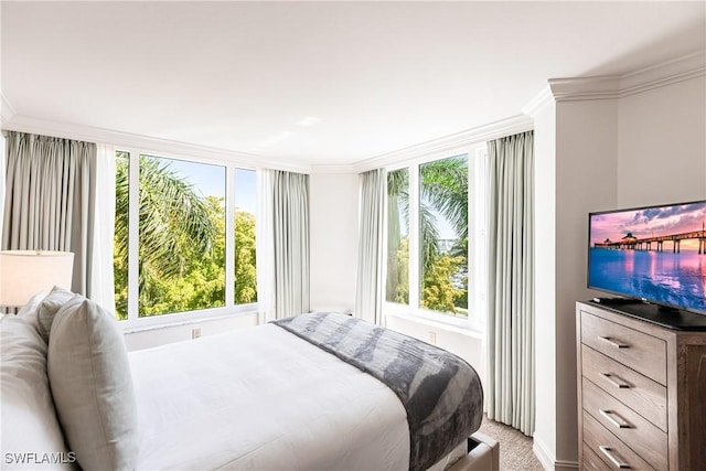 carpeted bedroom featuring multiple windows and crown molding