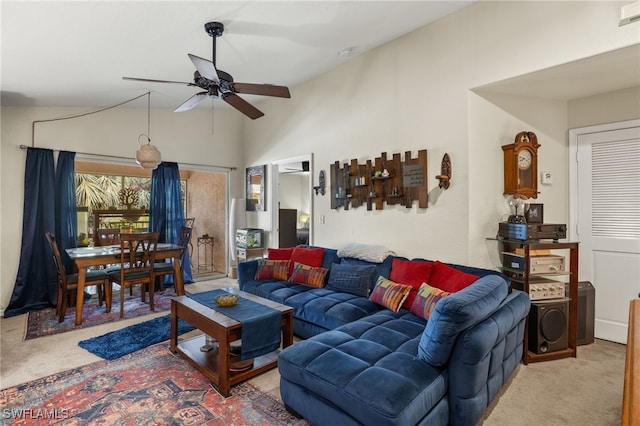 carpeted living room with ceiling fan and vaulted ceiling