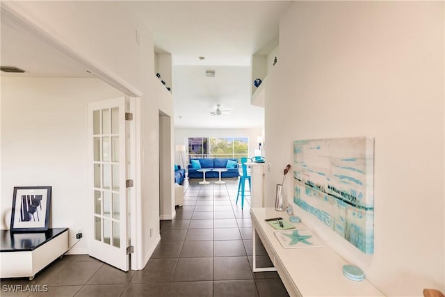 hallway featuring dark tile patterned floors