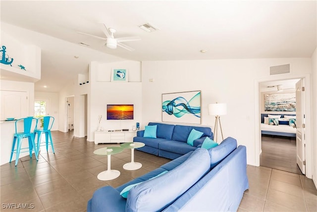 tiled living room with ceiling fan and vaulted ceiling