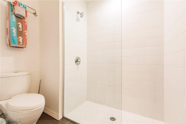 bathroom featuring toilet and a tile shower