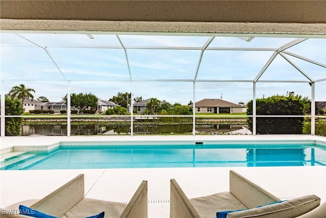 view of pool with glass enclosure and a water view