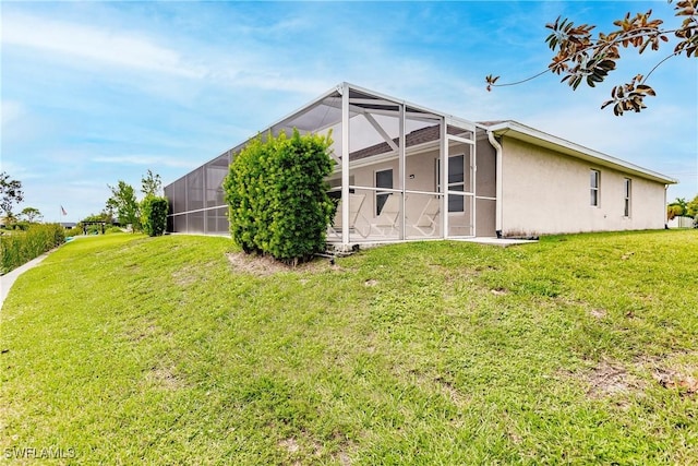 view of side of home featuring a lawn and glass enclosure