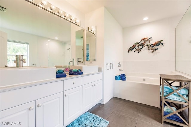 bathroom with tile patterned floors, vanity, and a tub