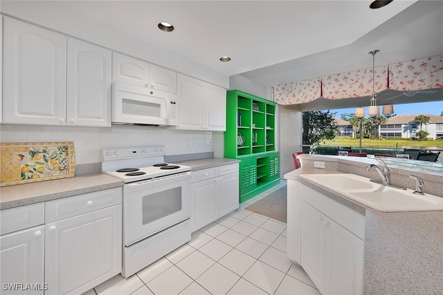 kitchen with white appliances, sink, hanging light fixtures, light tile patterned floors, and white cabinetry