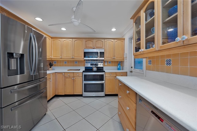 kitchen featuring ceiling fan, light tile patterned flooring, light countertops, appliances with stainless steel finishes, and glass insert cabinets