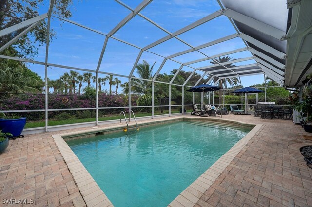 view of swimming pool with glass enclosure and a patio area