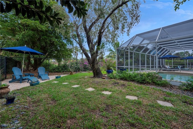 view of yard featuring a lanai, a patio area, an outdoor pool, and a fenced backyard