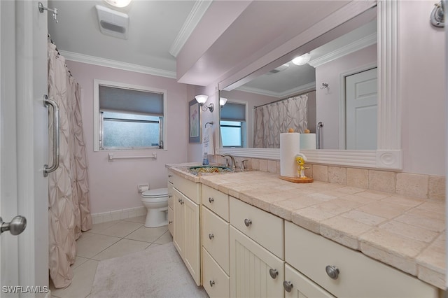 bathroom featuring tile patterned flooring, toilet, vanity, baseboards, and crown molding