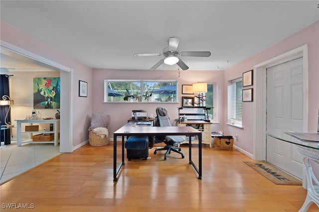 home office with ceiling fan, light wood-style flooring, and baseboards